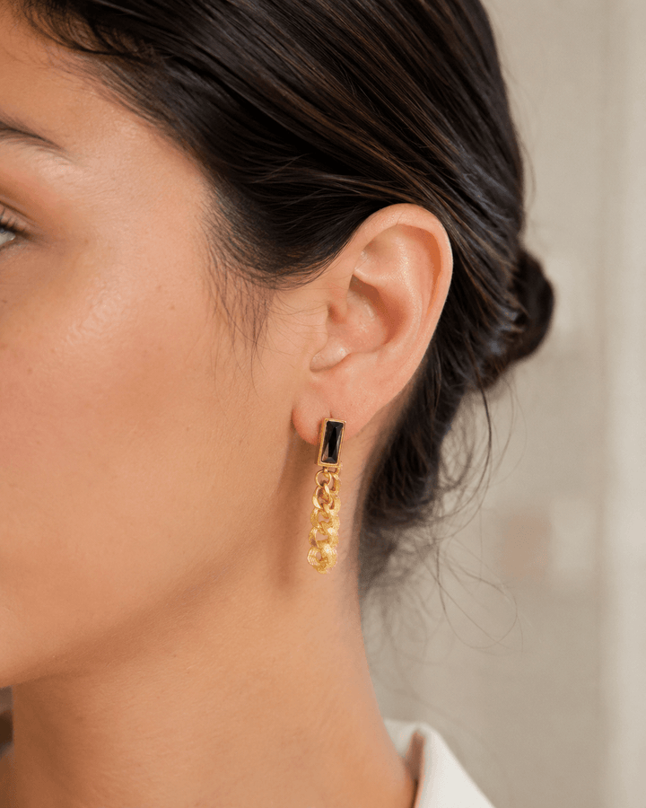 Black chain drop earrings worn on the ear
