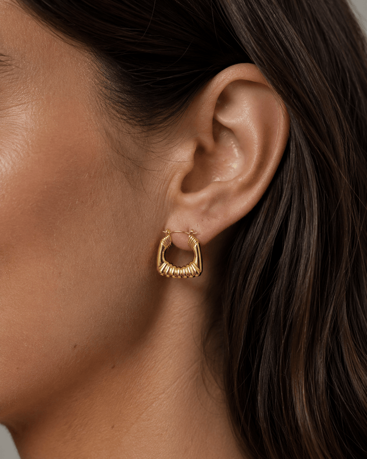 Ribbed hoop earrings worn on the ear